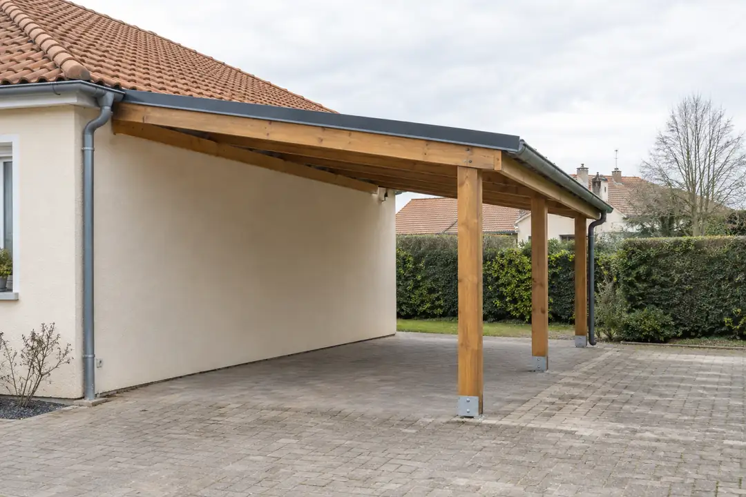 Carport bois adossé au pignon d’un pavillon, toiture en simple pente